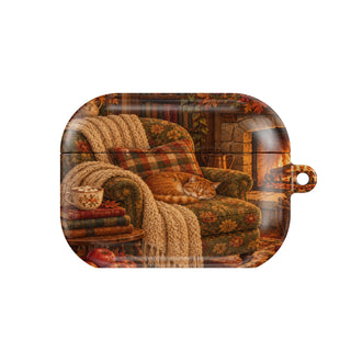 Cozy Reading Nook AirPods case — armchair by the fire with books, cocoa and a sleeping cat, closed front view