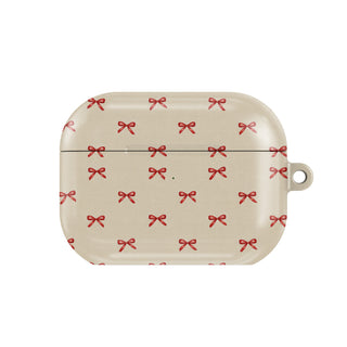 Tiny Red Bows AirPods case — tiny cherry-red bows scattered on soft cream, closed front view