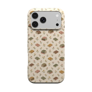 Tiny Books phone case — little stacks of vintage books and wildflowers on cream, MagSafe iPhone case, front view