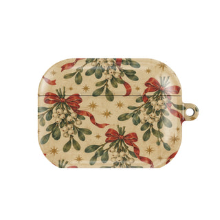 Mistletoe & Ribbons AirPods case — mistletoe sprigs tied with red ribbon bows on aged cream, closed front view