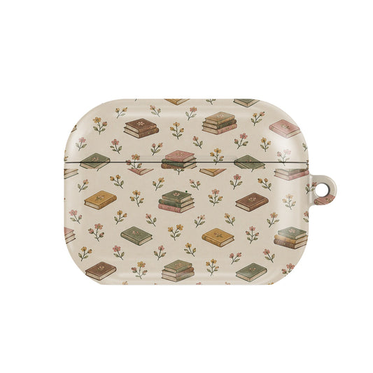 Tiny Books AirPods case — little stacks of vintage books and wildflowers on cream, closed front view