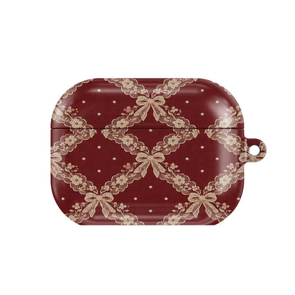 Burgundy Lace AirPods case — blush lace trellis with ribbon bows on burgundy, closed front view