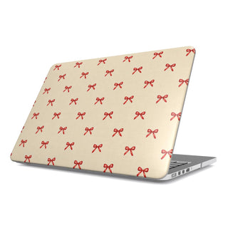 Tiny Red Bows MacBook case — tiny cherry-red bows scattered on soft cream, hard-shell laptop cover, angled lid view