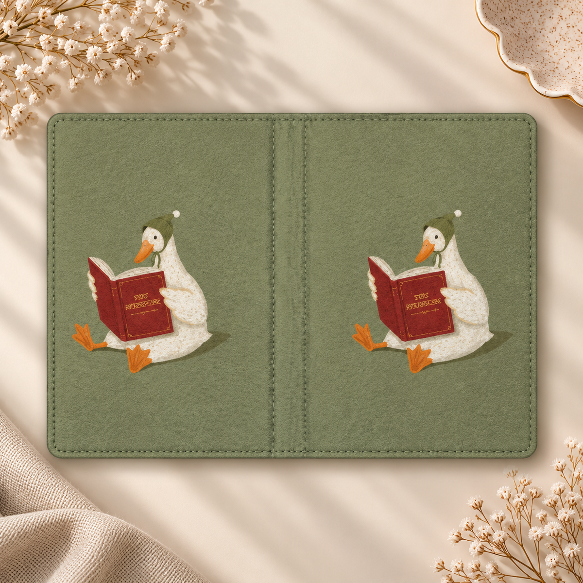 Reading Duck Kindle case opened flat, front and back — white duck reading a red book on sage green