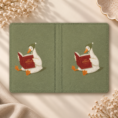 Reading Duck Kindle case opened flat, front and back — white duck reading a red book on sage green