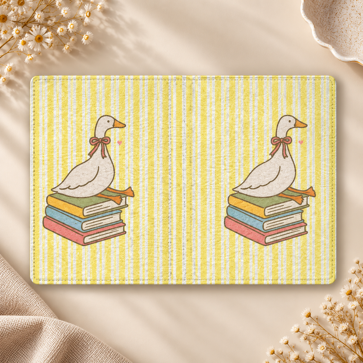 Reading Goose Kindle case opened flat, front and back — goose with a pink bow sitting on books, yellow stripes