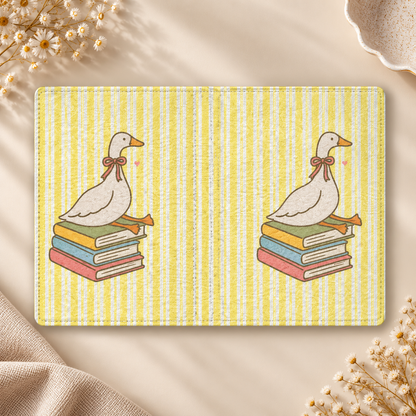 Reading Goose Kindle case opened flat, front and back — goose with a pink bow sitting on books, yellow stripes