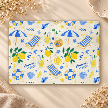 Summer Seaside Kindle case opened flat, front and back — blue umbrellas, deck chairs, shells and lemons on cream