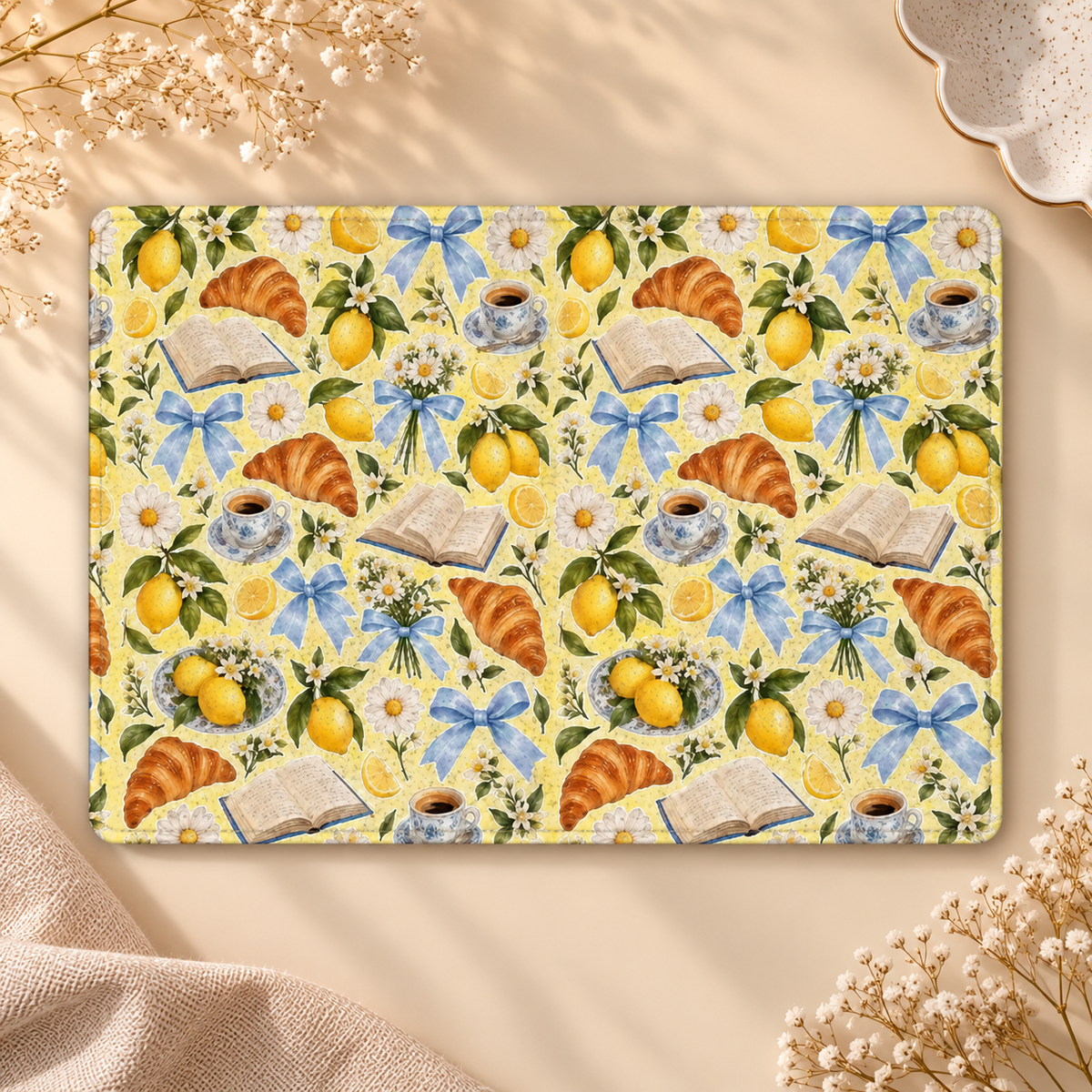 Lemons & Croissants Kindle case opened flat, front and back — lemons, croissants, open books and blue bows on yellow